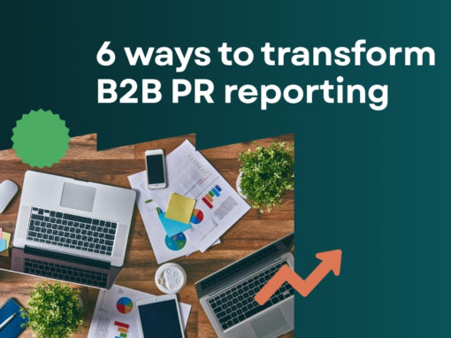 A brown desktop with a laptop, a smartphone, some plants and print outs of a Released PR report. The text on the image states: 6 ways to transform B2B reporting.